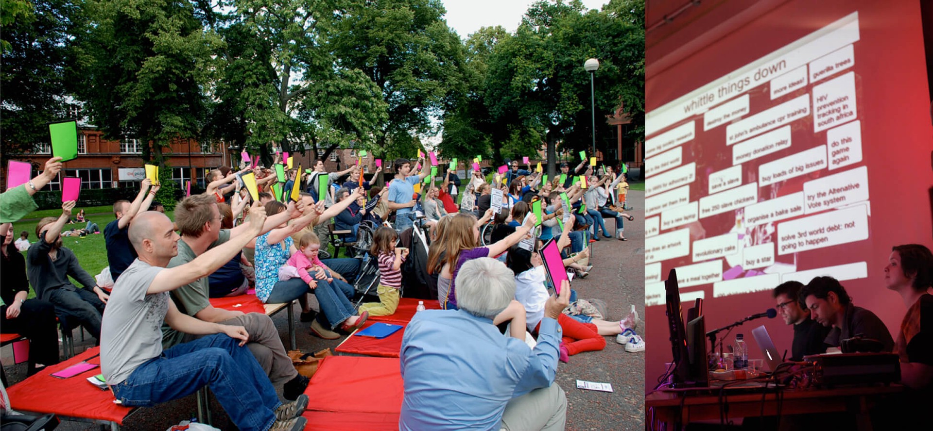 A group of people holding up coloured voting cards at a fun outdoor event